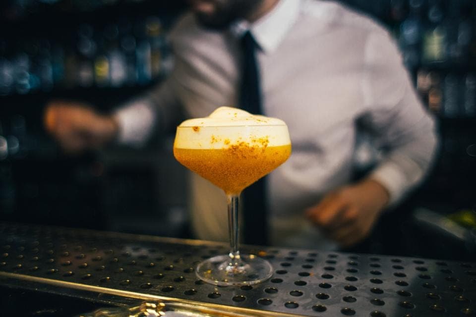 A bartender finishing a cocktail on the bar